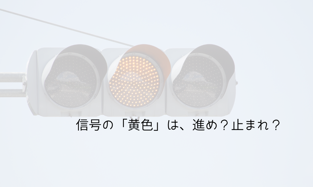 「黄色信号を写した信号機の写真」